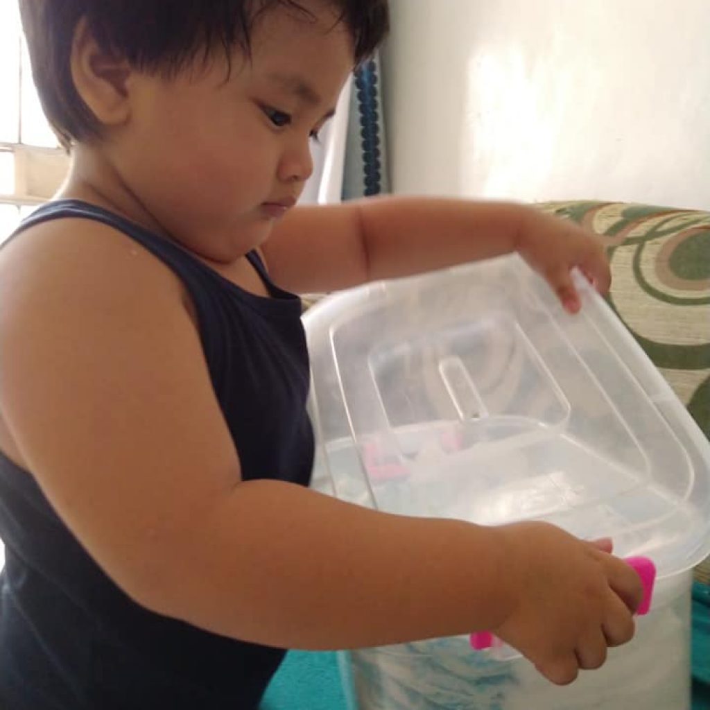 Toddler keeping his diapers in a box