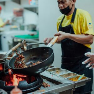 a man cooking using a wok