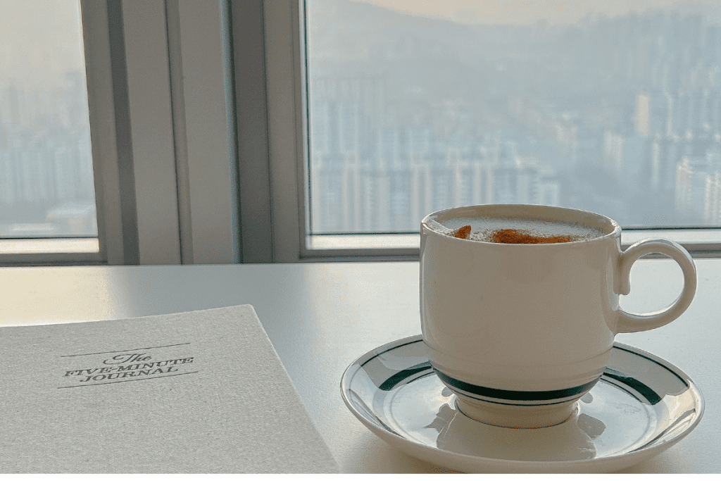 Coffee cup with a five-minute journal for slow living